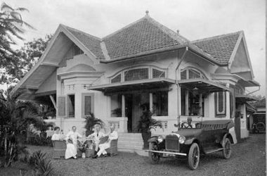 COLLECTIE TROPENMUSEUM Theedrinkende Europeanen voor een woonhuis in Batavia met naast hen de auto met chauffeur T Mnr 60001630
